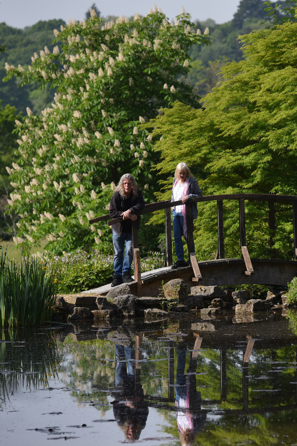 Couple standing on bridge looking across lake